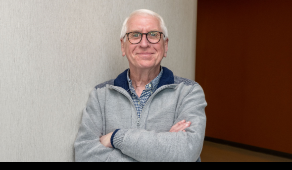 Photo of smiling man with his arms crossed